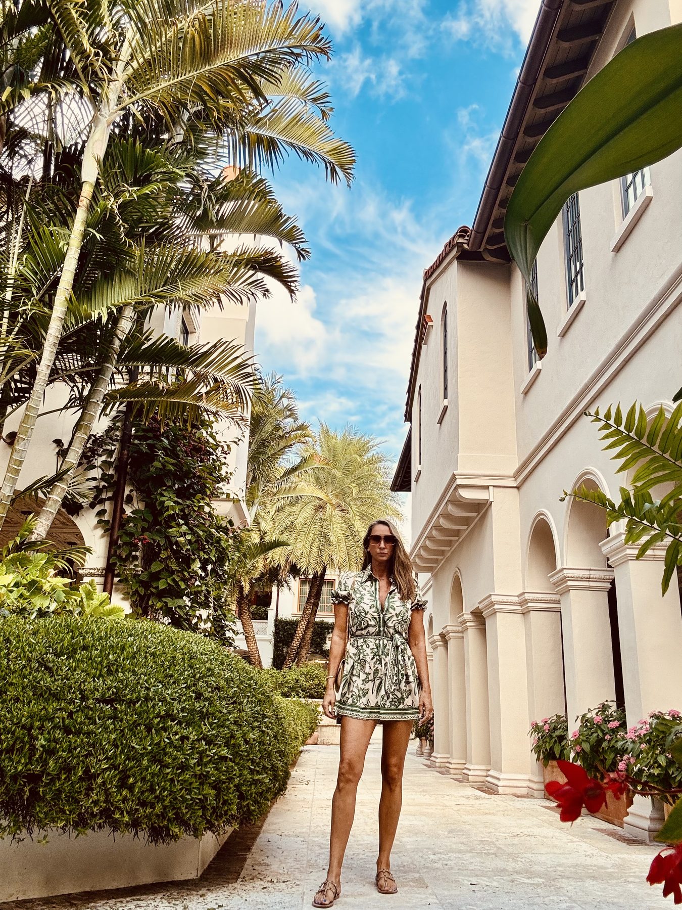 Kelly O’Shea in a green-print dress in a Palm Beach courtyard